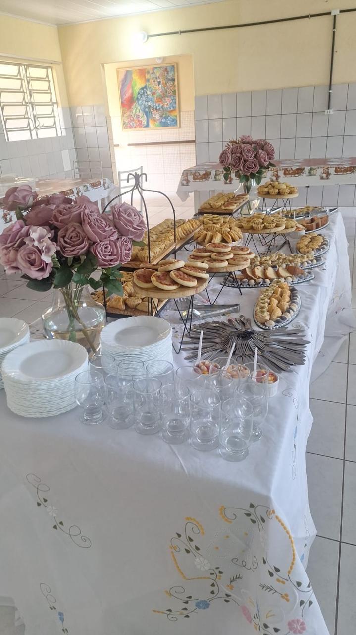 Mesa de confraternização decorada com salgados e doces